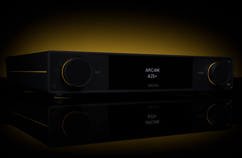 Arcam A25+ integrated amplifier in black on a reflective surface with warm amber backlighting